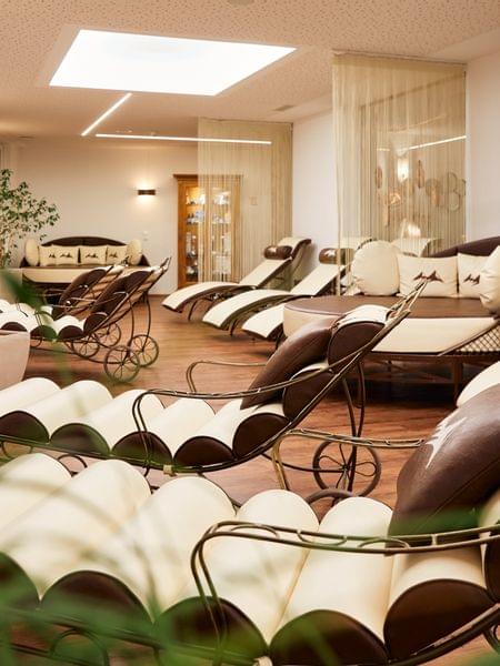 Saunabereich und Ruheraum Eleganter Wellnessbereich mit komfortablen Relaxliegen und Pflanzen im warmen Licht